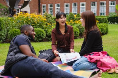 Three students lounging in courtyard of Regent's University London.