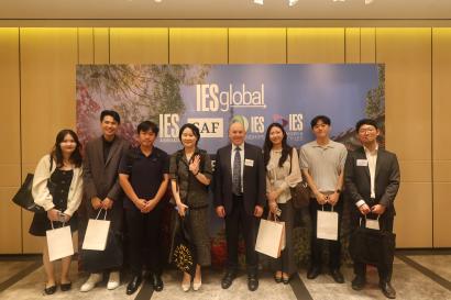 IES Global staff, including CEO Dr. Greg Hess, with alumni in front of an IES Global banner.
