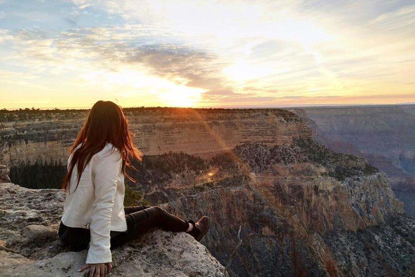 Student sitting on the edge of the Grand Canyon