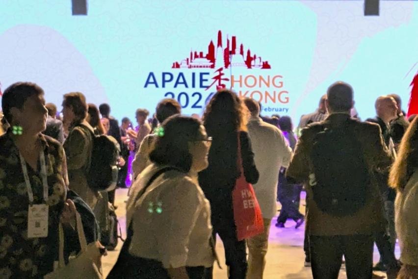 Crowd in front of a large presentation screen during the opening reception of APAIE 2026.