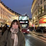 A student poses on the high street of Central London at night