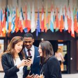 Three students in front of the European Council in Brussels Belgium