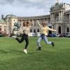 Two students jump for a fun photo in front of Neue Burg in Vienna