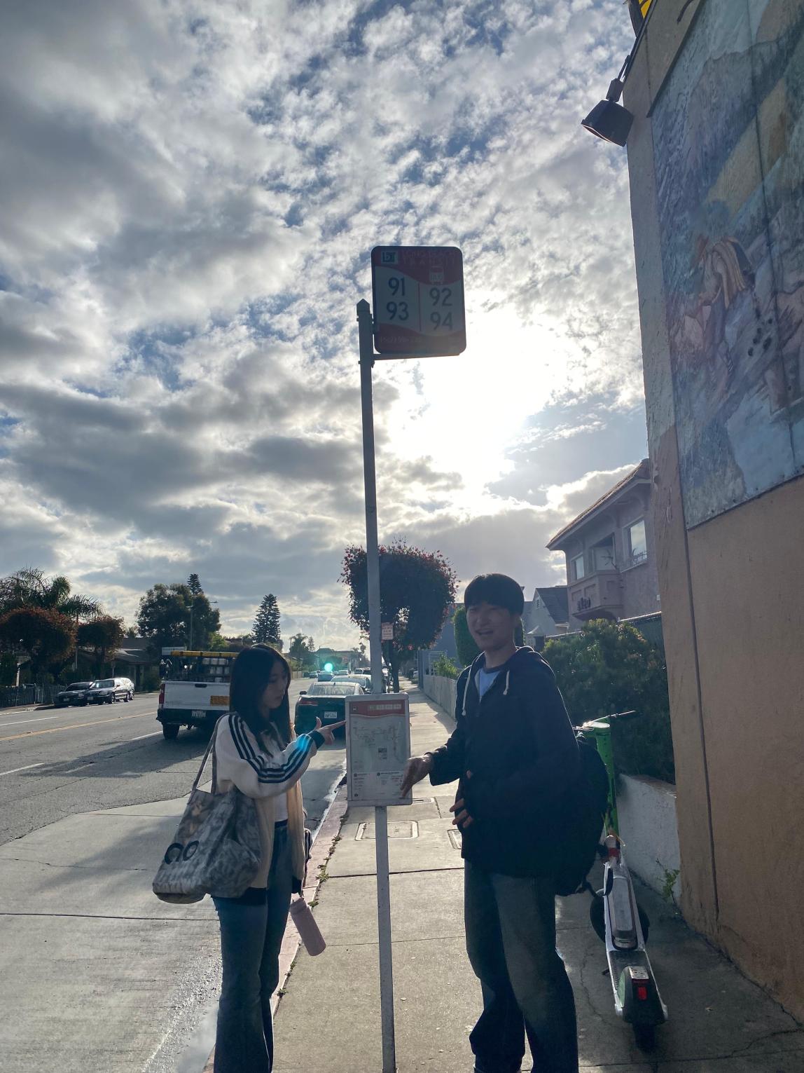 Two students at a bus stop in Long Beach.