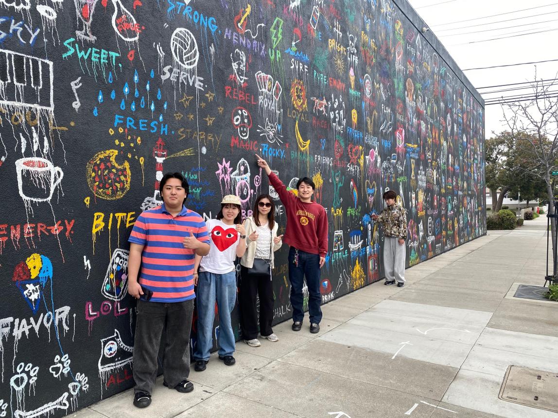 Students posing at an art mural.