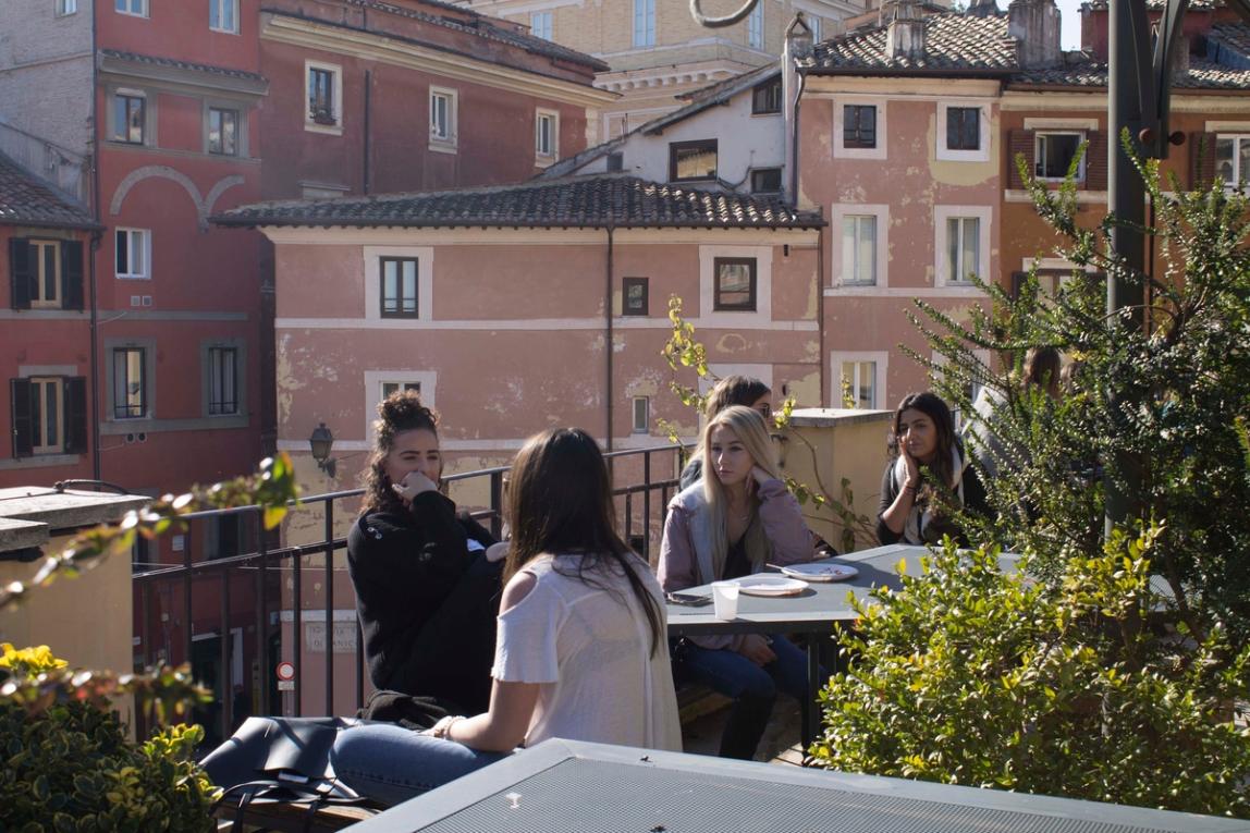 Group of female students conversing on the outside patio of the IES Abroad Rome Center.