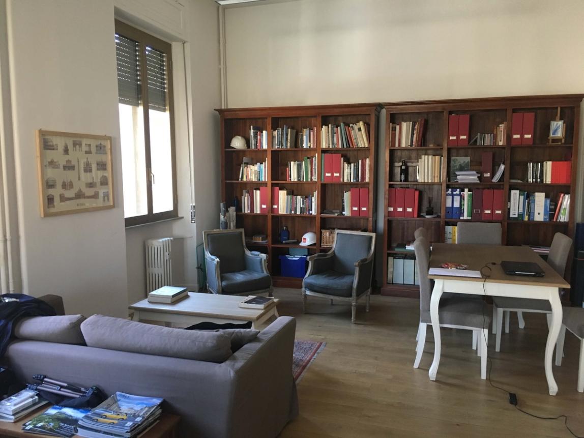 Corner of the hub in the IES Abroad Rome Center: bookshelves, chairs and a sofa.