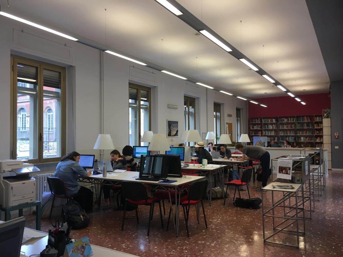 Wide view of the hub at the IES Abroad Rome Center, with students working at the tables.
