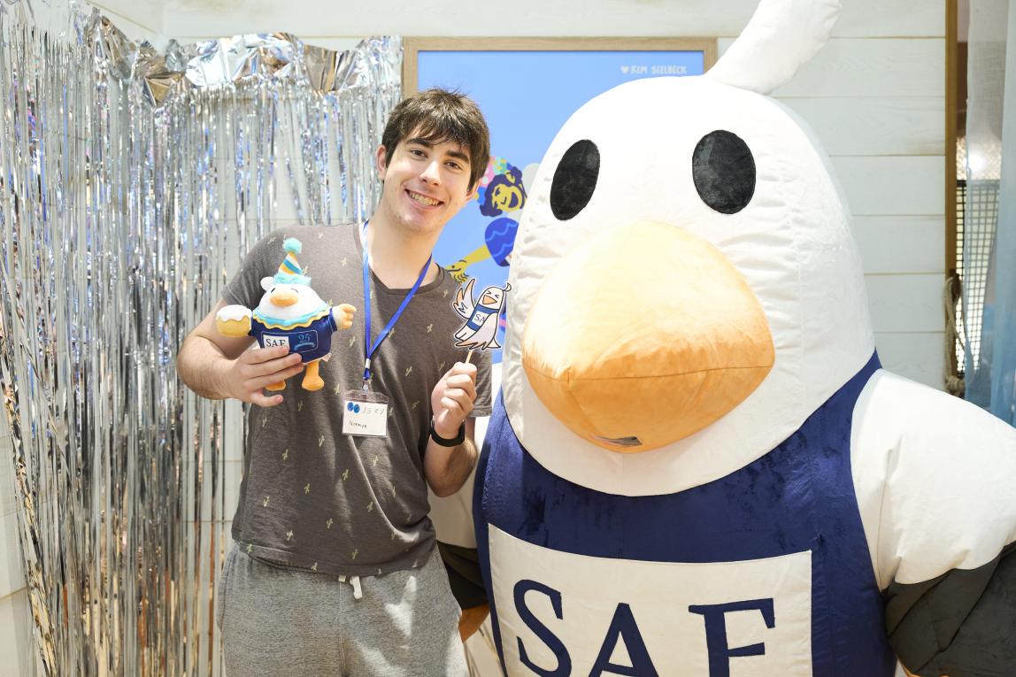 Student holding 25th Anniversary SAFFY plushie, posing with SAFFY mascot.