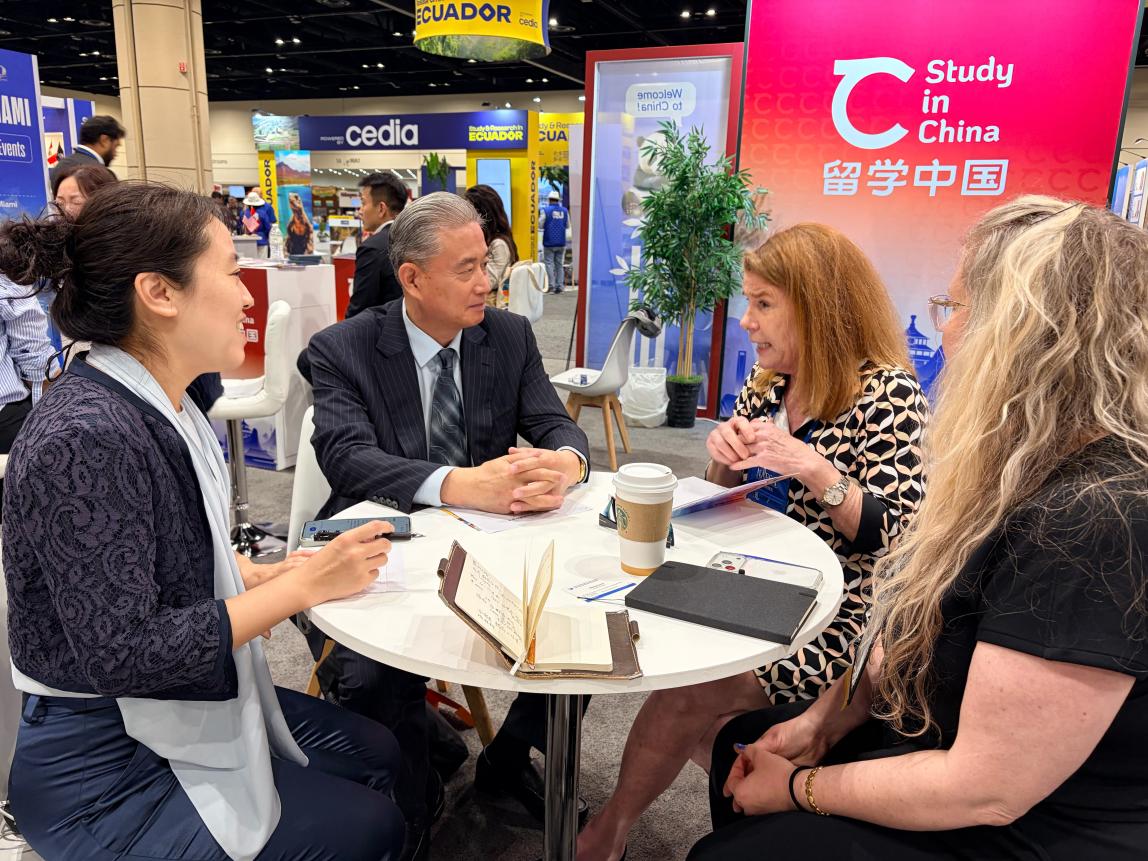 SAF leadership chatting with university partners around a table inside convention.
