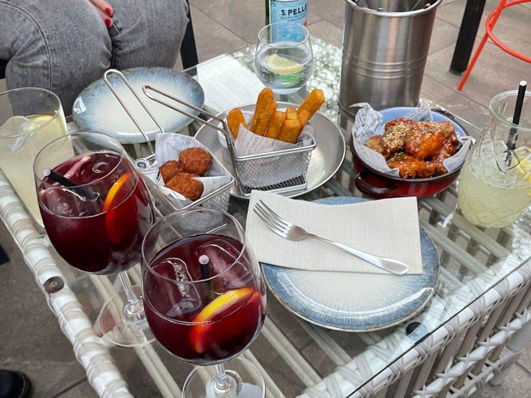 A small table full of typical Spanish food and drinks—including a couple glasses of tinto de verano.