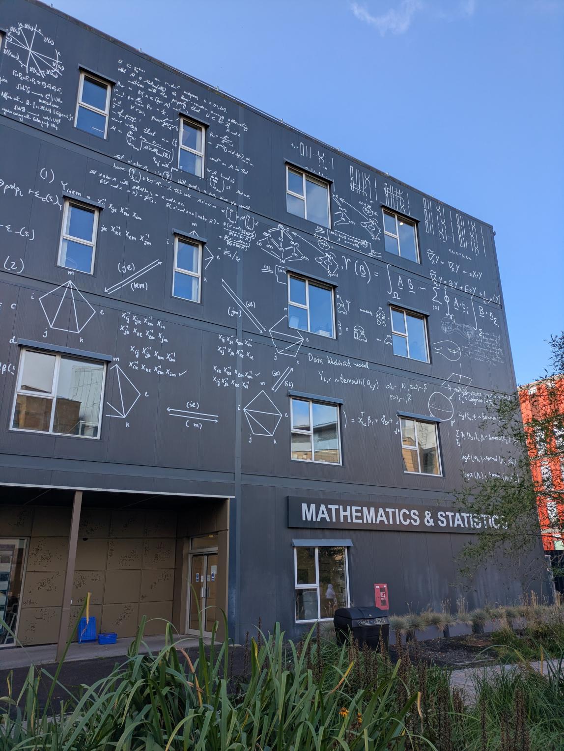 Grey "Mathematics & Statistics" building with math markings inscribed throughout. 