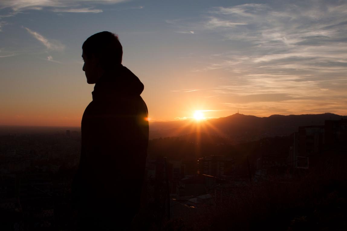 a student looks out over Barcelona from the Bunkers during sunset