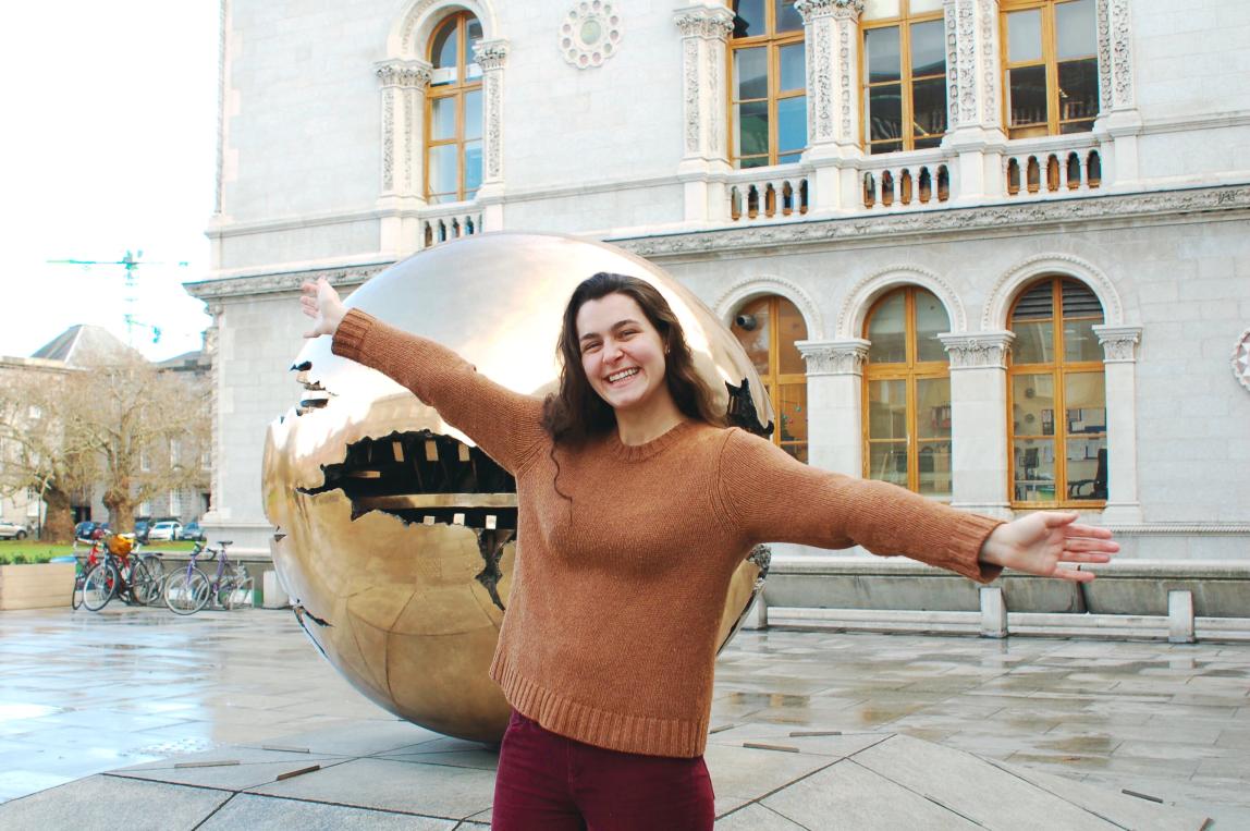 a student poses for a photo in front of Trinity College Dublin