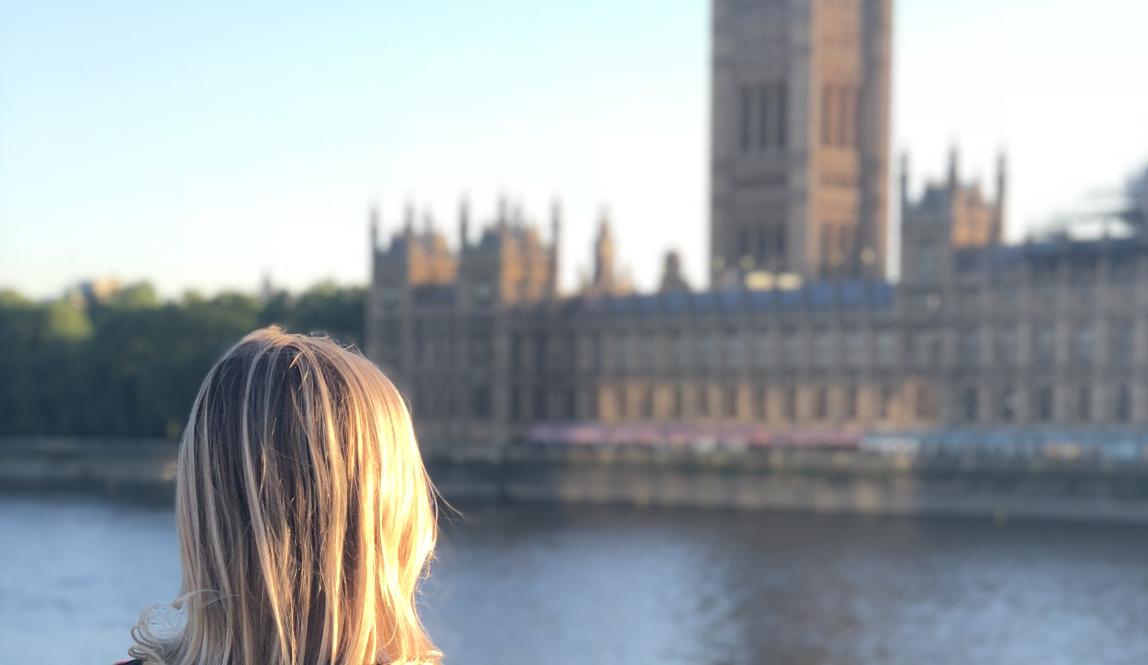 a student looks across the river Thames at British Parliament in London
