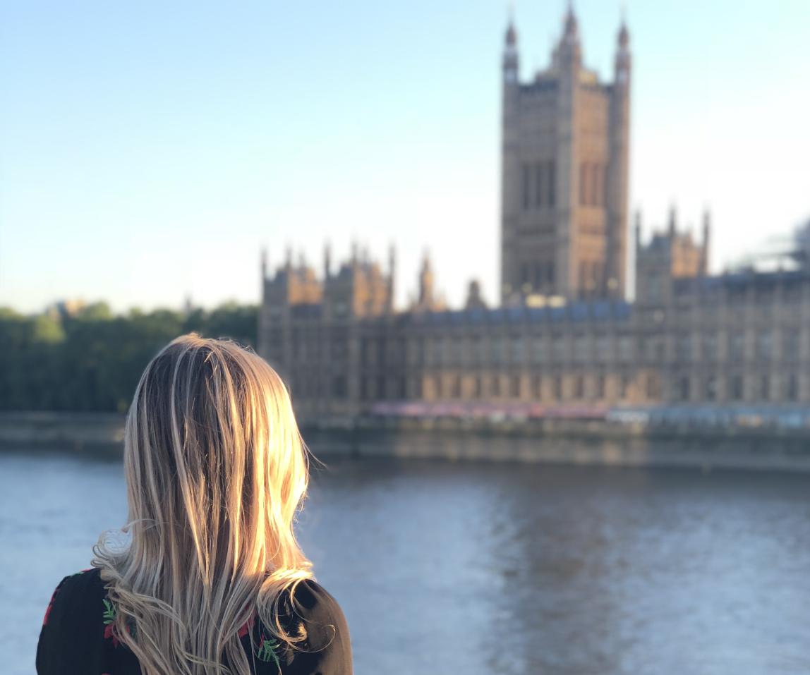 a student looks across the river Thames at British Parliament in London