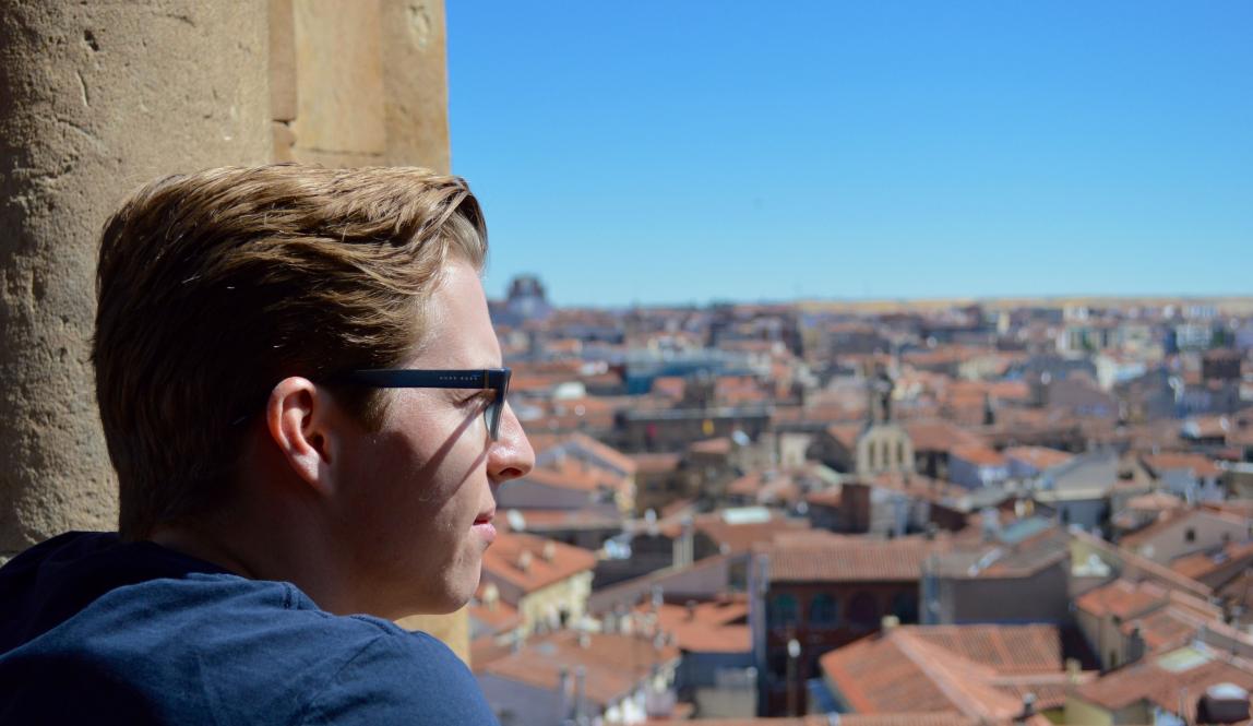 a student looking out over Salamanca from the rooftops