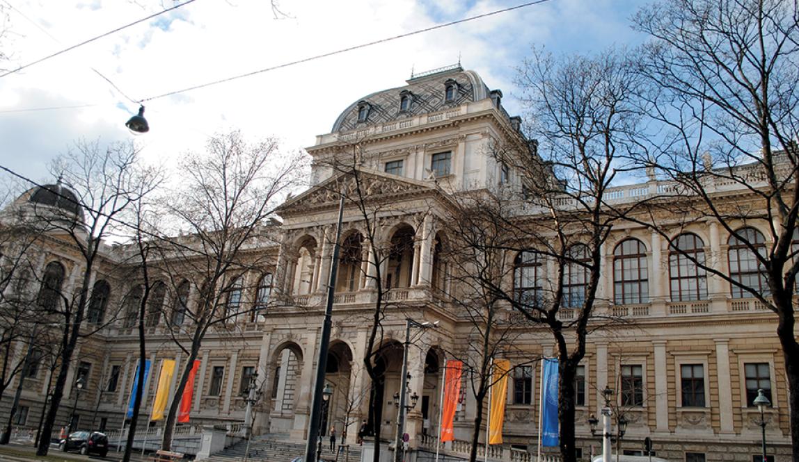 The entrance to University of Vienna, a cream-colored building with European-style architecture.
