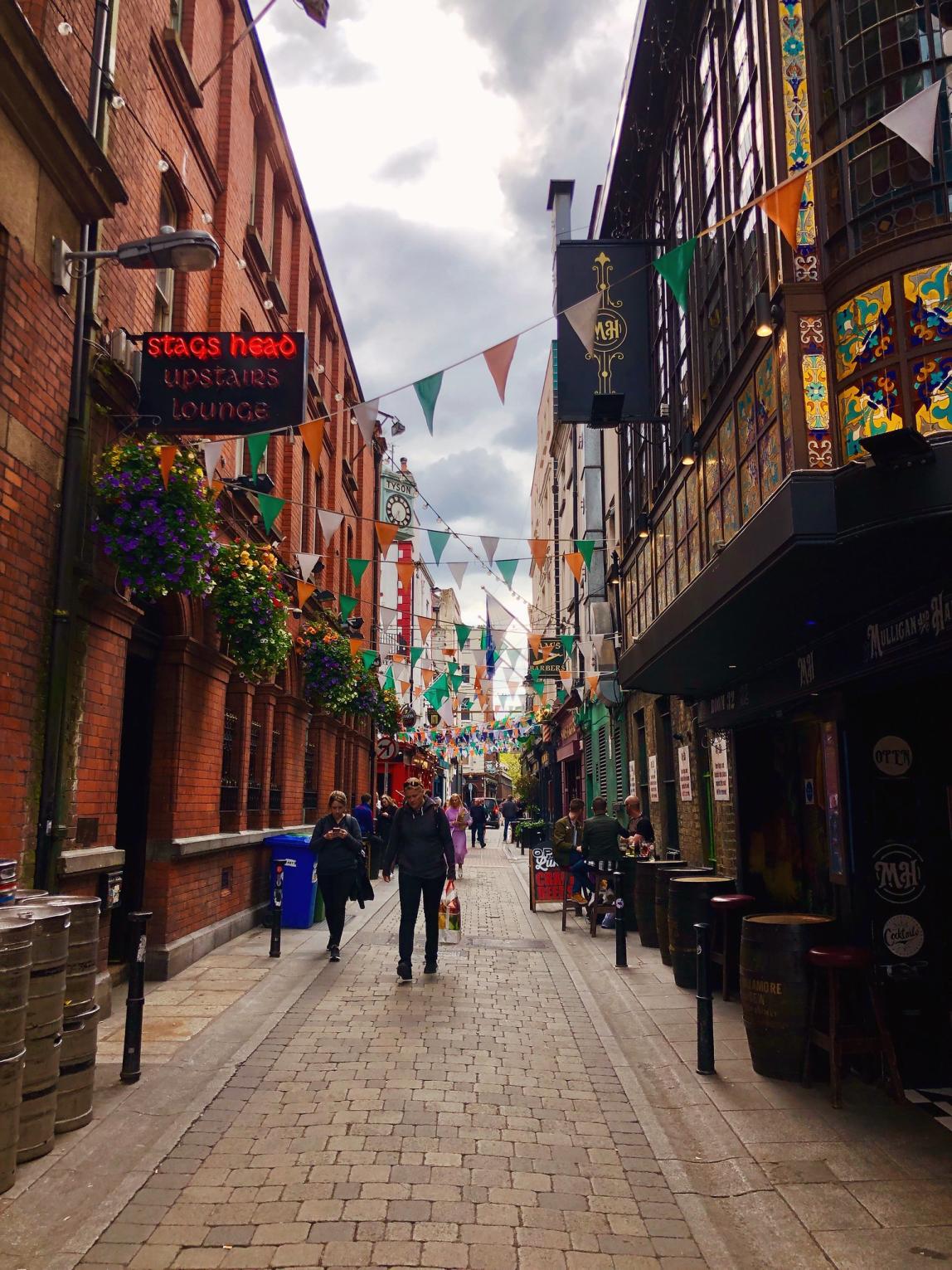 a street in Temple Bar lined with green and orange flags