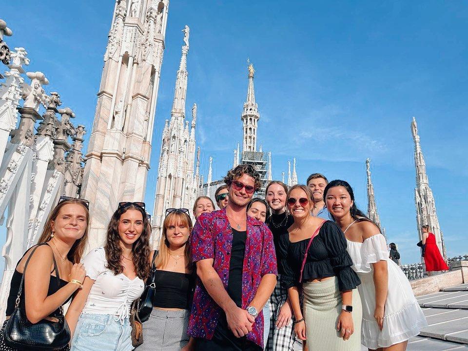 A group of students smile outside Il Duomo in Milan, Italy.