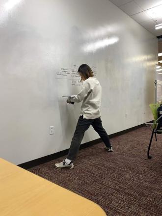 A student writes on a white board to study