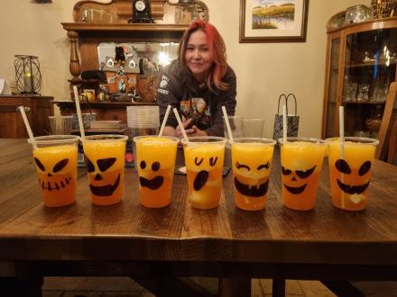 A party host poses with a row of cups of rootbeer floats
