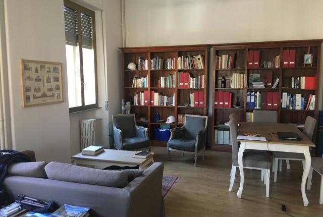 Corner of the hub in the IES Abroad Rome Center: bookshelves, chairs and a sofa.