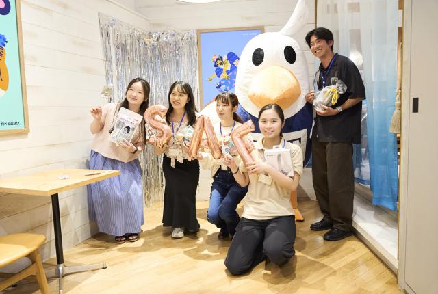 5 students pose with the SAFFY mascot, all holding SAF merch and trivia prizes.
