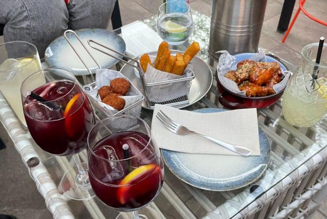 A small table full of typical Spanish food and drinks—including a couple glasses of tinto de verano.