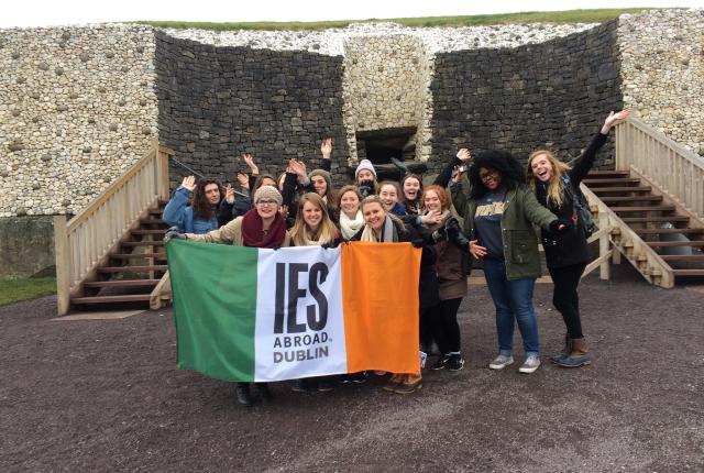 a group of students pose with an IES Abroad Dublin flag