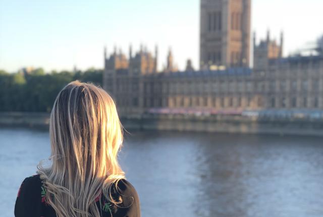 a student looks across the river Thames at British Parliament in London