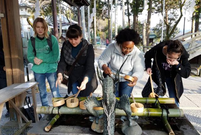 students drink water at a temple in Japan