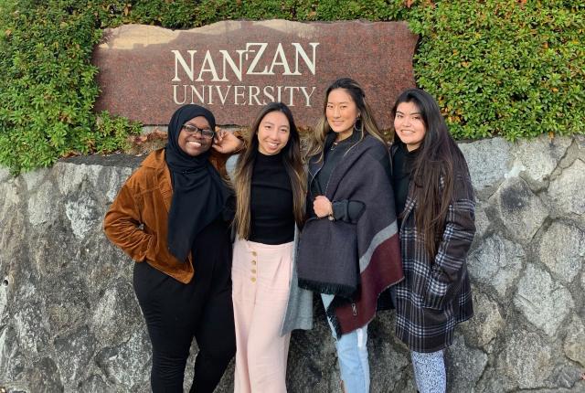 students pose for a photo in front of the Nanzan University sign in Nagoya