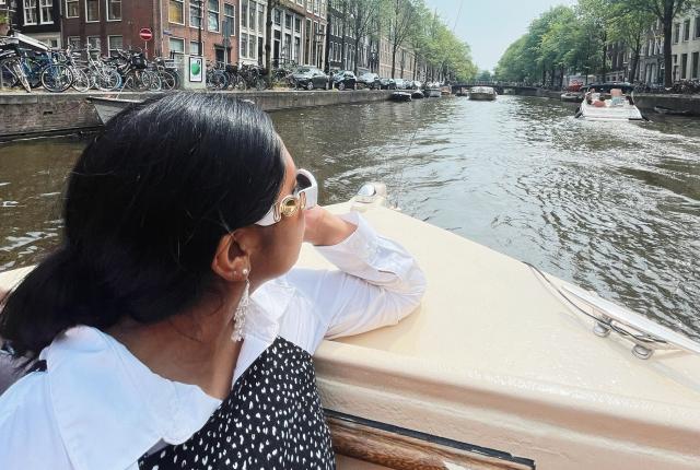 a student riding through the Amsterdam canals on a boat