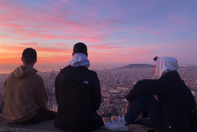three male students look out over Barcelona from the Bunkers