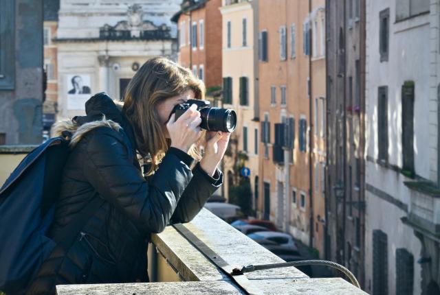 a student taking a photo on a rooftop in Rome