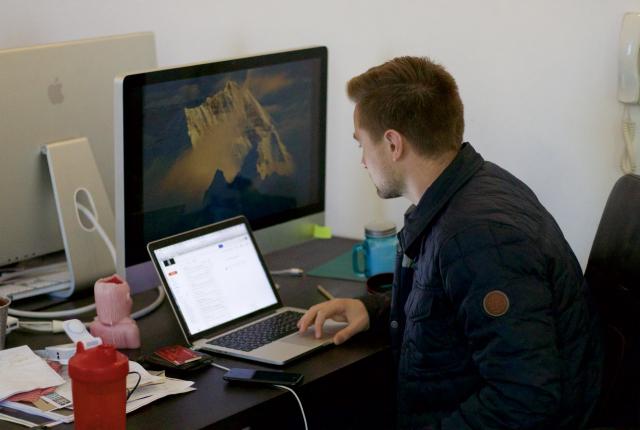 a student sitting at a desk typing on a laptop computer