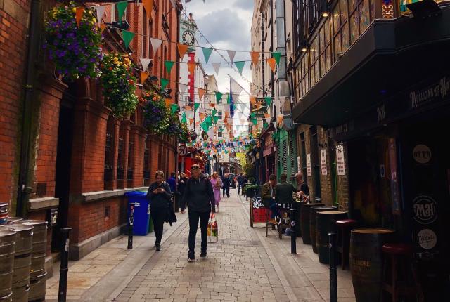 a street in Temple Bar lined with green and orange flags