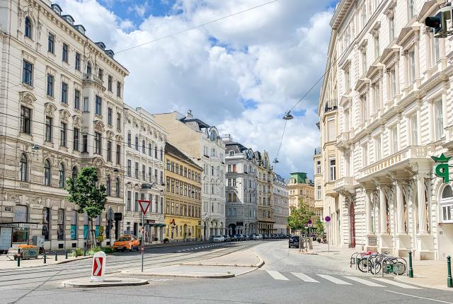 An empty street in Vienna, Austria lined with white buildings.