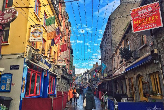 irish side streed at sunset lined with pubs, brick buildings, and a blue sky