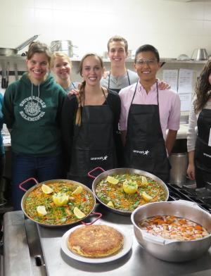 a group of students pose for a photo during a paella cooking class