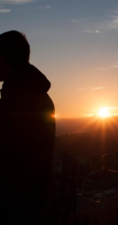 a student looks out over Barcelona from the Bunkers during sunset