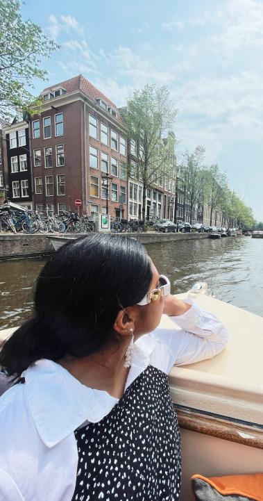 a student riding through the Amsterdam canals on a boat