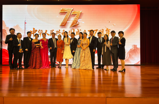 Performers from the China National Opera House in front of a large 77th Anniversary PRC backdrop..