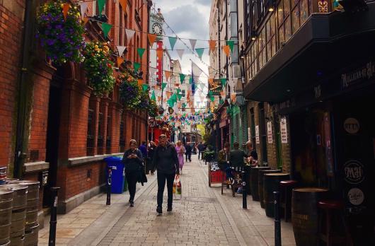 a street in Temple Bar lined with green and orange flags