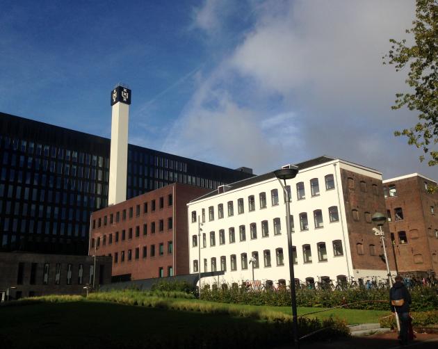 A large brick building sits on the Universiteit van Amsterdam's campus.