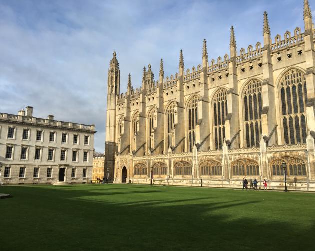 Cambridge King's College pictured on a sunny day. The building has gothic architecture and is a cream color.