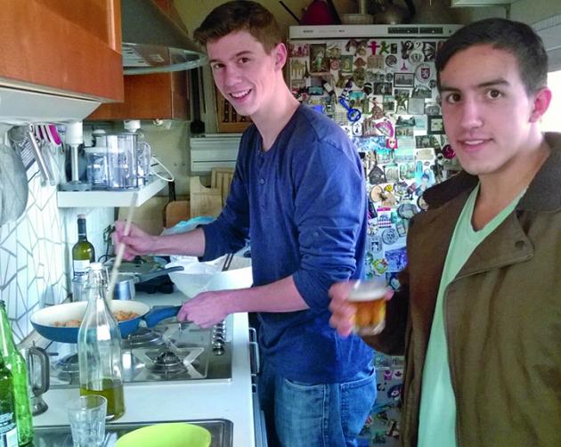 Two students cook in a small, rustic kitchen in Milan.
