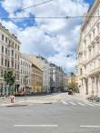An empty street in Vienna, Austria lined with white buildings.
