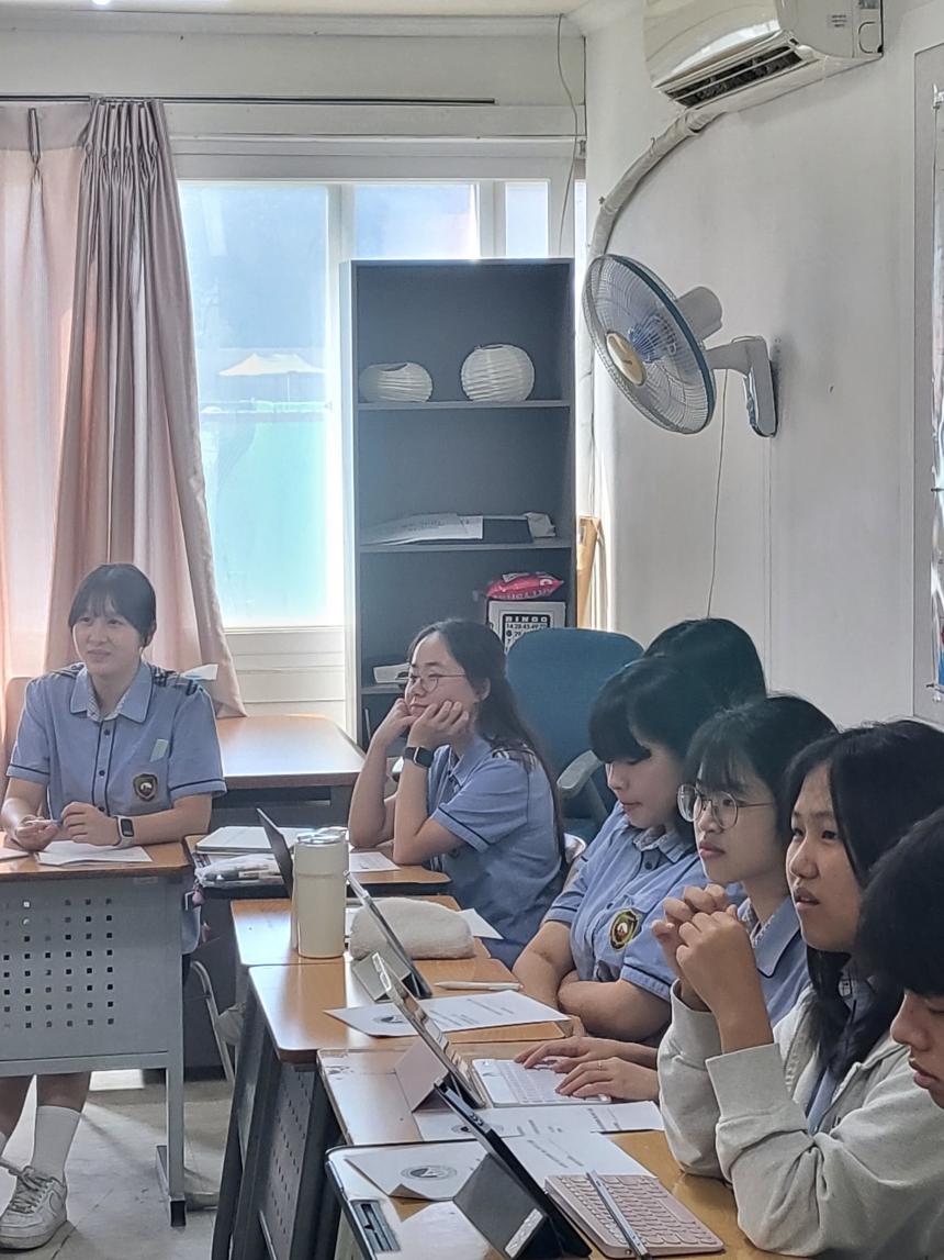 A group of high school students in a marketing and management class listen to a presentation by SAF Korea Director Suyeon Lee. 